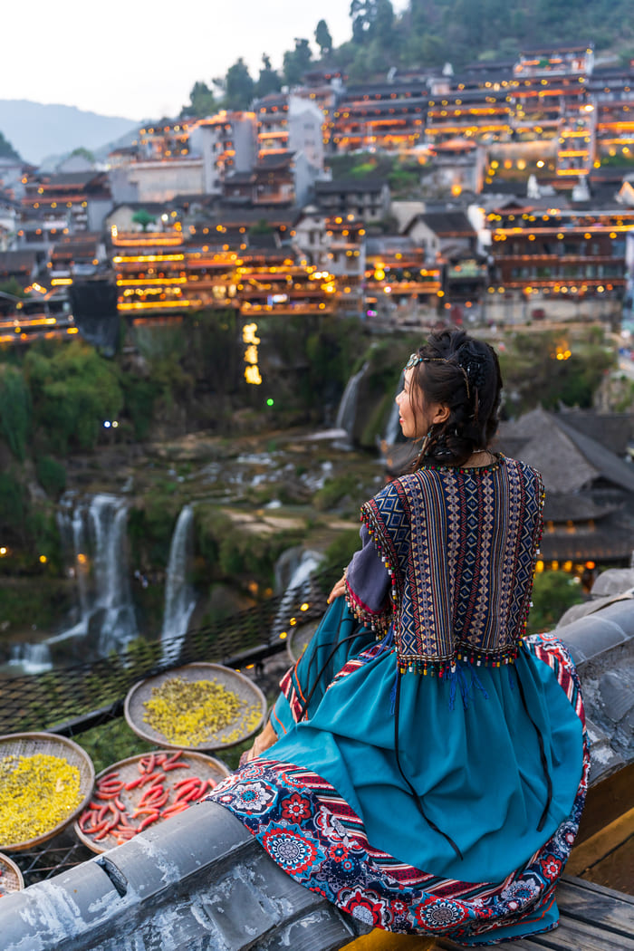 persona sentada contemplando la ciudad de lijiang, china